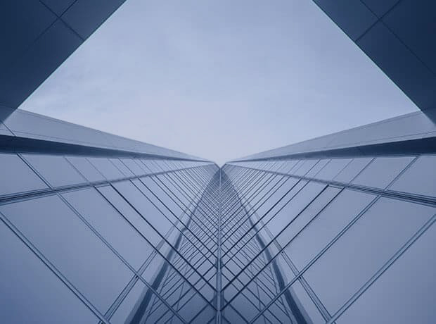 Looking up the side of a beautiful glass sky scraper forming a geometric pattern with the sky