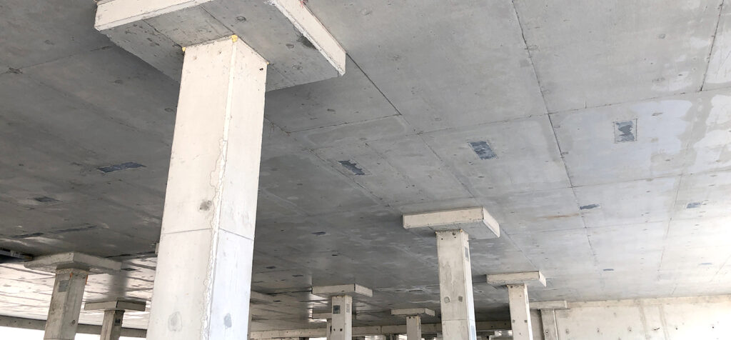 A picture of reinforced concrete pillars holding up the concrete ceiling slab